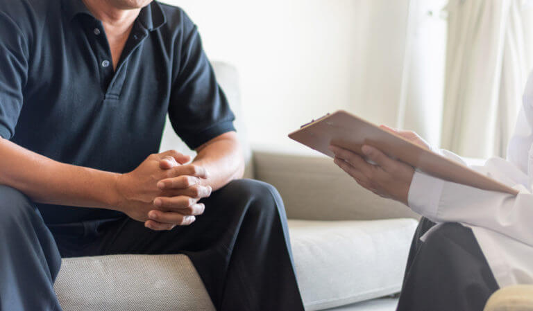 Doctor physician consulting with male patients in hospital fro Erectile Symptoms