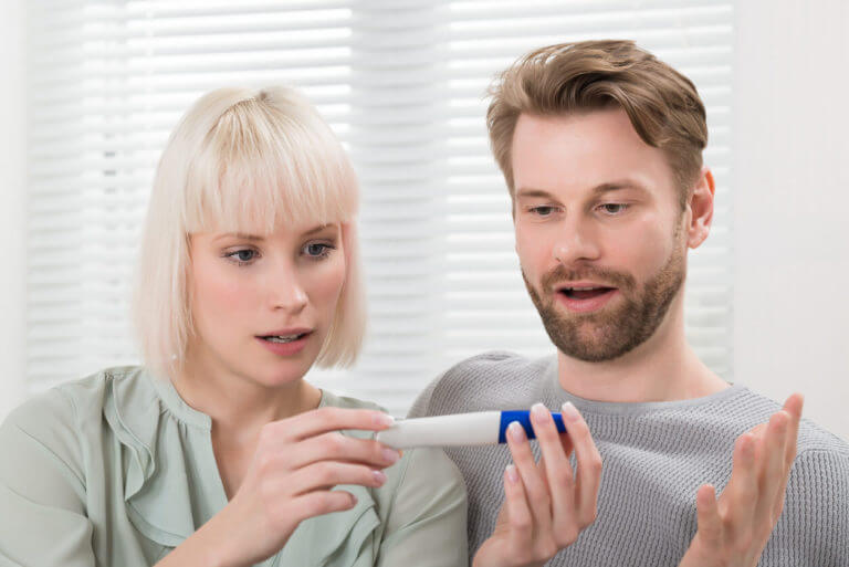 Caucasian Couple Looking At Pregnancy Tester and Discussing about Male Fertility.
